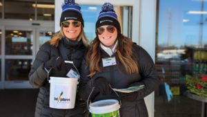 Two people holding donation buckets.