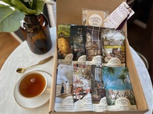 A glass of tea next to a variety of tea bags.