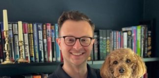 A person holding a bag of tea and a dog.