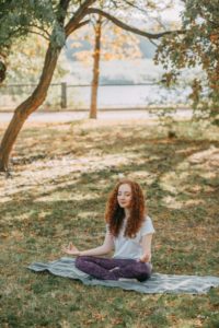 A person meditating in the park.