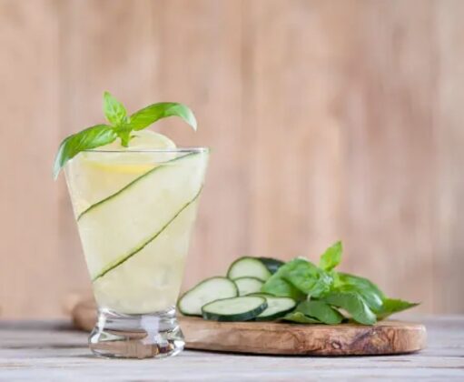 A yellow liquid in a glass garnished with greens.