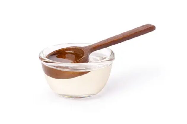 a clear, tiny bowl with a wooden spoon resting inside.