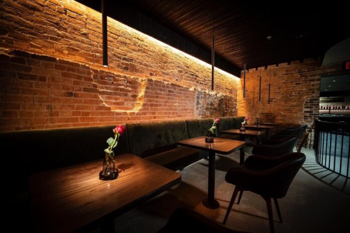 Restaurant table with rose on it.