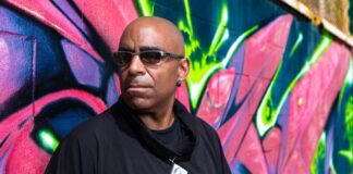 A photo of someone standing against a wall.