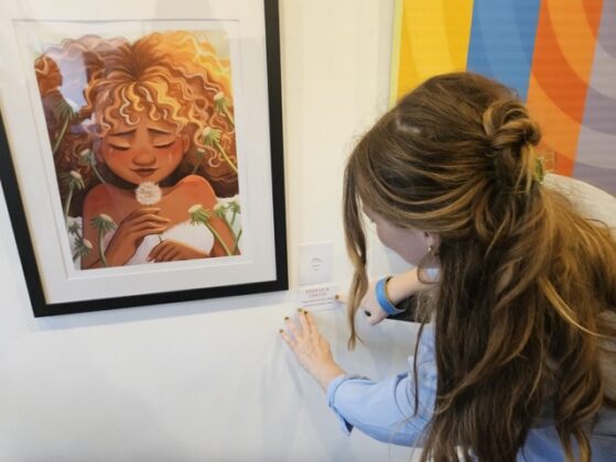 A person standing near a painting.