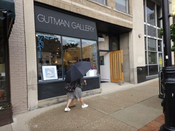 A person walking outside an art gallery.