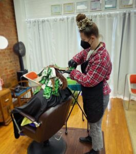 A stylist at bg studios coloring a client's hair.