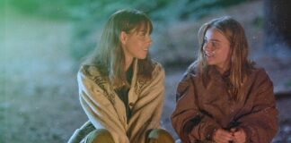 Two people sitting down outside.