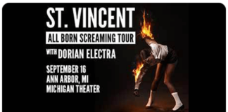 black background with a person slamming burning guitar at ground