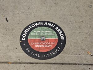 Red and green sticker on sidewalk.