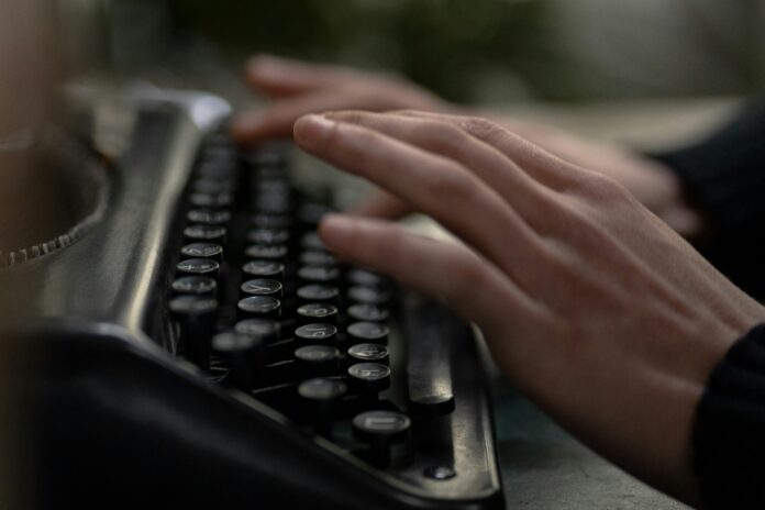 hands typing on typewriter