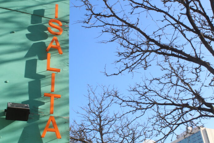 Blue vertical sign with orange letters