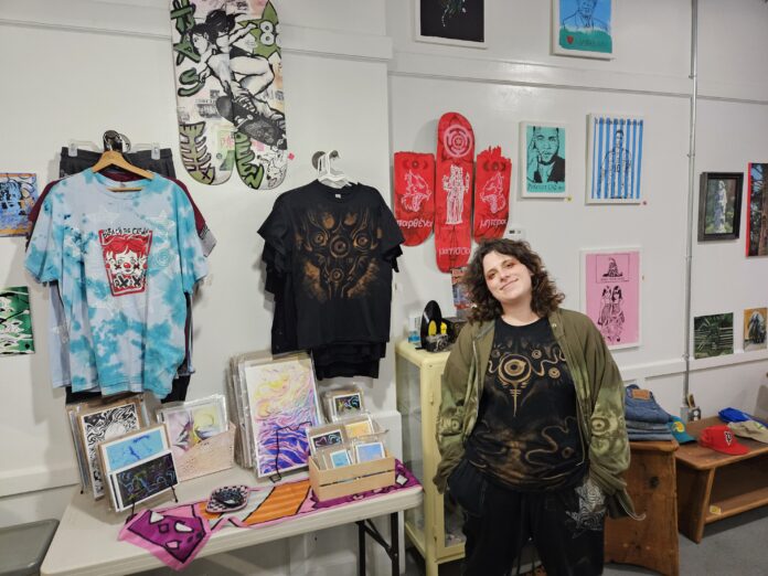 Andie Ziemkowski standing alongside her wares at Vacancy. Photo by Drew Saunders.