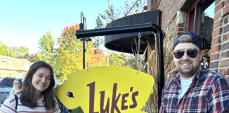 Assignment editor, Mary, with husband and baby in front of "Luke's Diner."