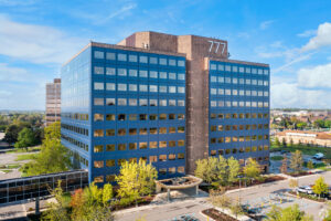 Large office building reflecting the sky.
