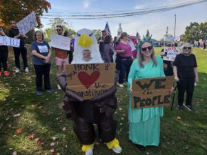 Someone dressed up like the Statue of Liberty at the Ypsi No Kings gathering, joined by someone in a bald eagle costume. Photo by Drew Saunders.