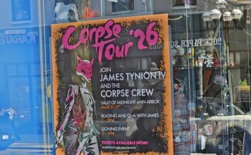 The Corpse Tour '26 poster in the front window of Vault of Midnight. Photo by Drew Saunders.